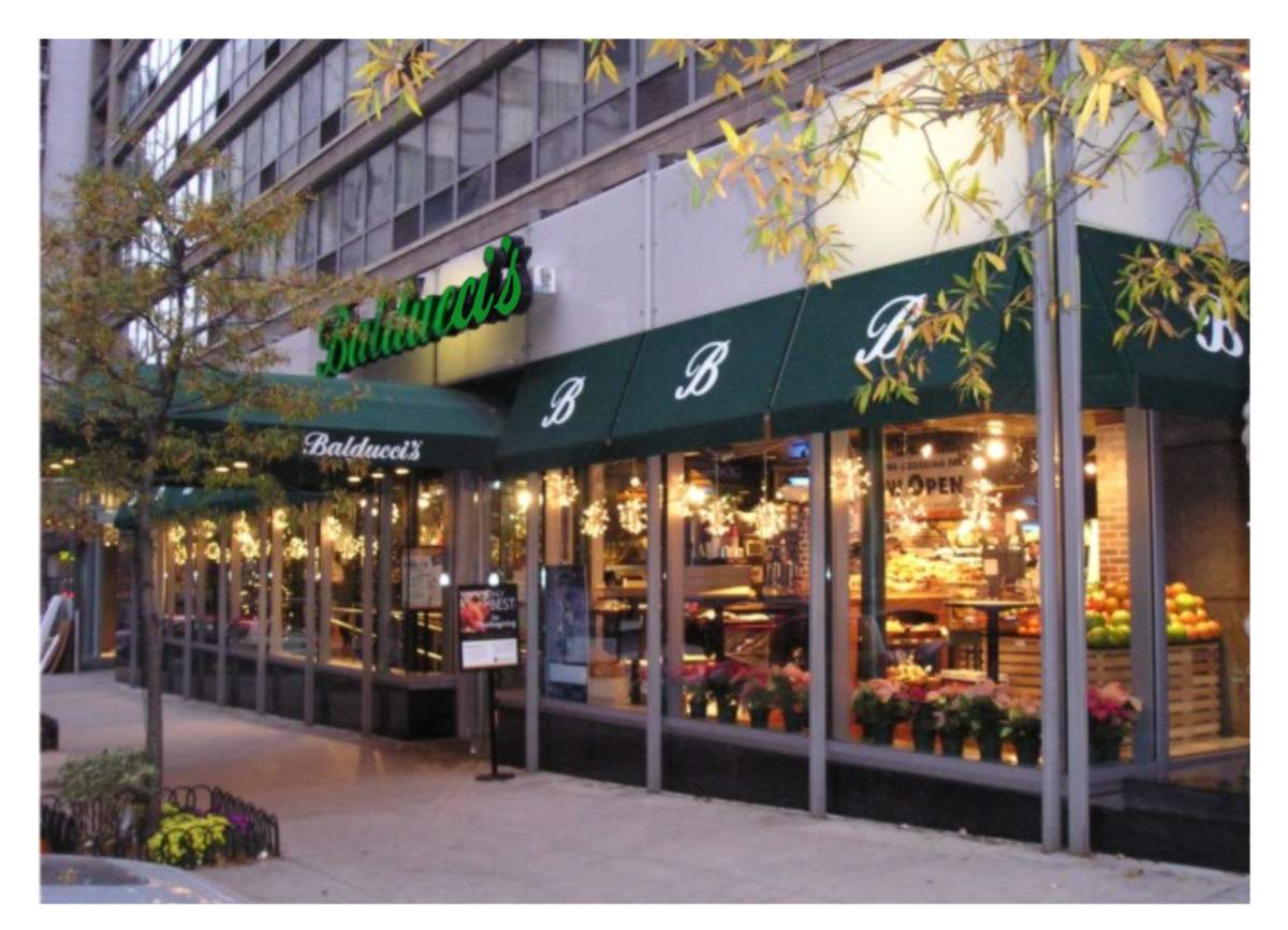 Photo of Balducci’s Food Lover’s Market storefront green awnings and green backlit logo sign at Lincoln Square New York City